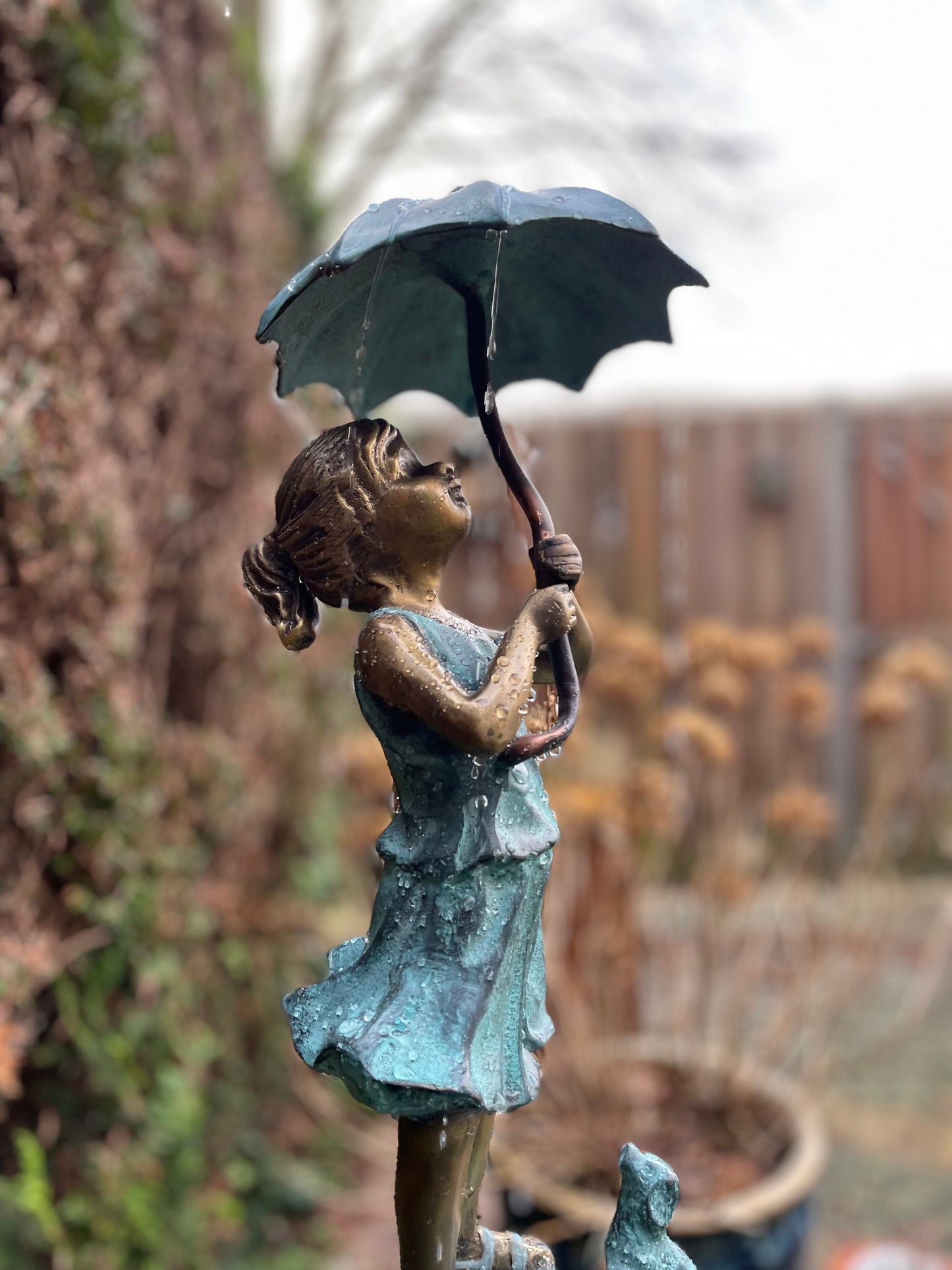 Menina de bronze sob fonte de guarda-chuva - decoração de jardim