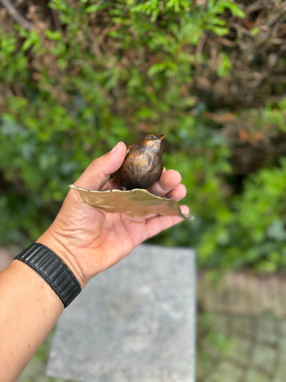 Pardal de bronze em pé na folha